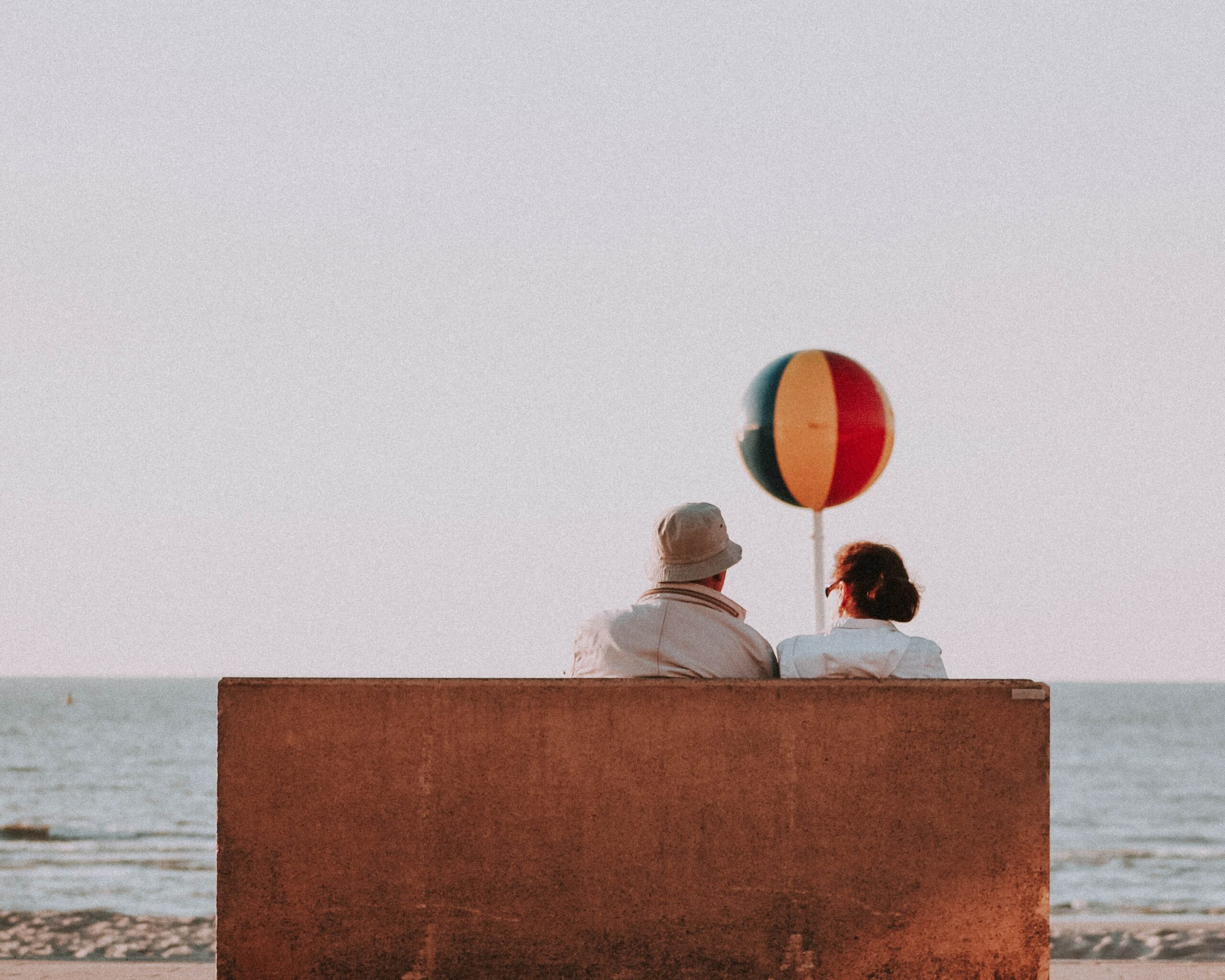 Picture of couple sitting on a bench with the ocean view